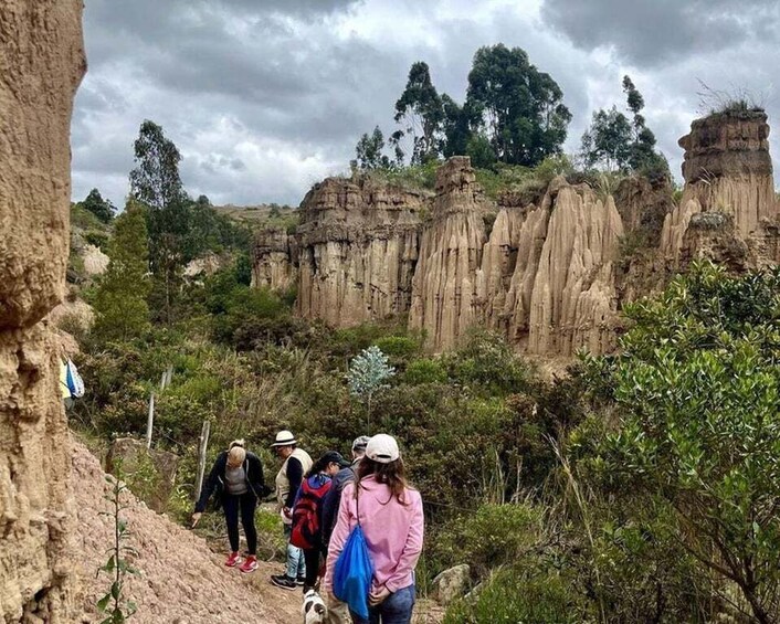 A group of hikers on a rocky trail with distinctive rock formations in the background. 1
