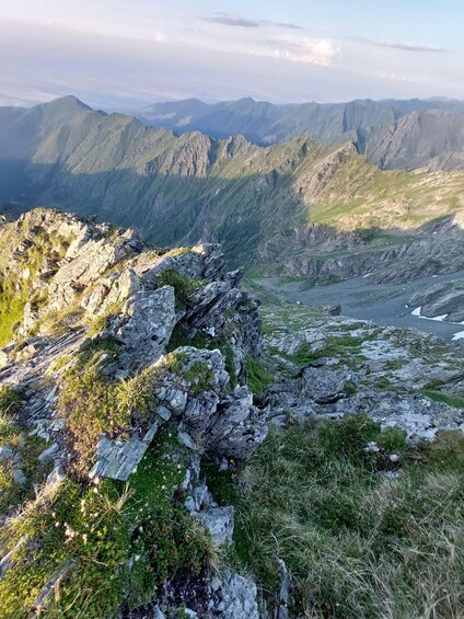 A mountainous landscape with rocky outcrops and patches of grass. 2