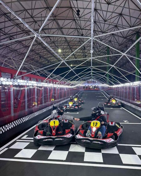 A go-kart racing track with multiple lanes and go-karts numbered 1 and 12. 1