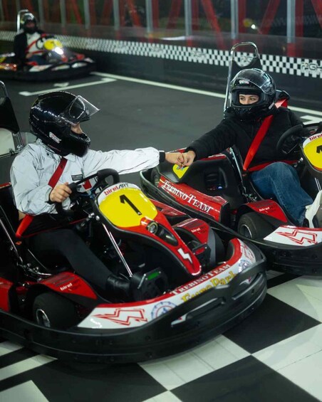Two go-karts with racing numbers 1 and 2 on a checkered track. 4