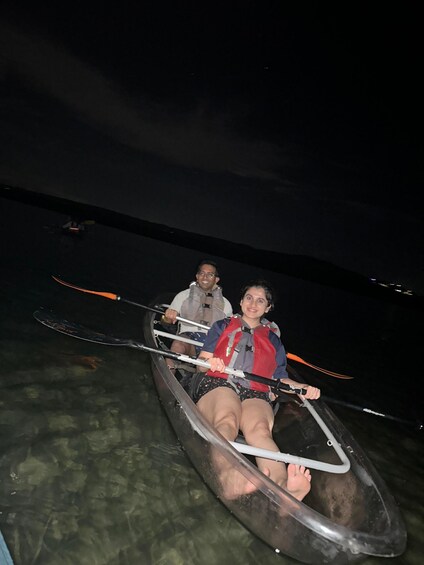 Two people in a canoe on a body of water at night. 5