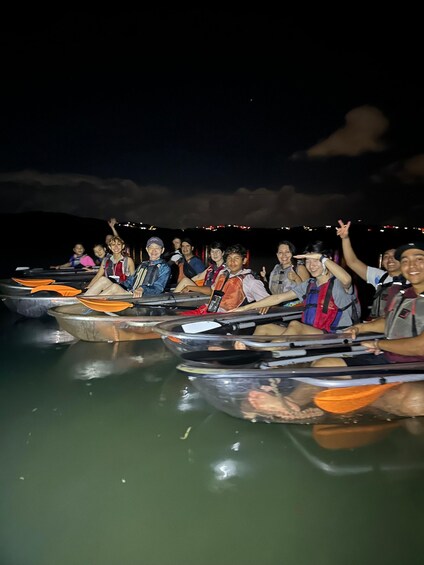 A group of people in kayaks on a body of water at night. 1