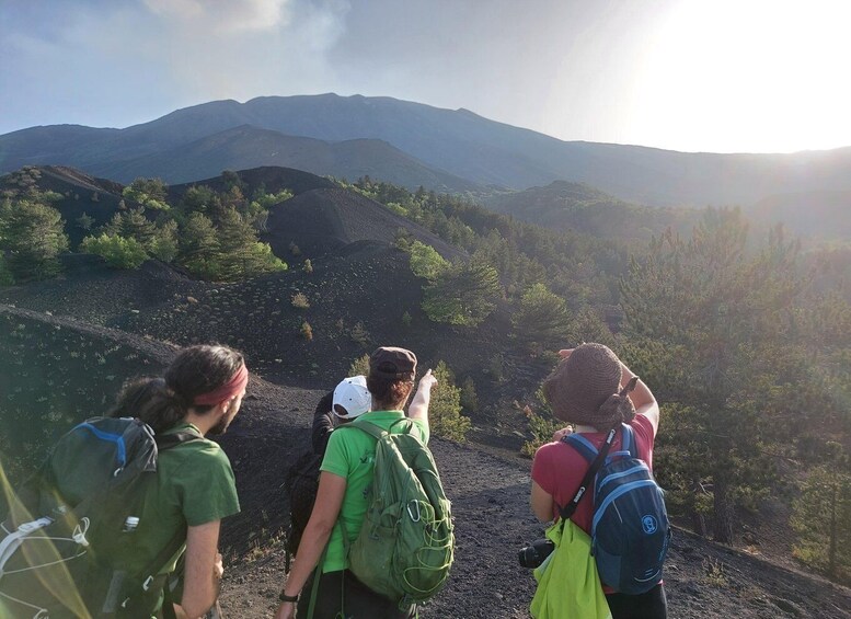A group of hikers on a mountain trail with a view of distant mountains and a clear sky. 3