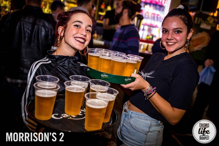 Two people holding a tray of beer glasses. 1