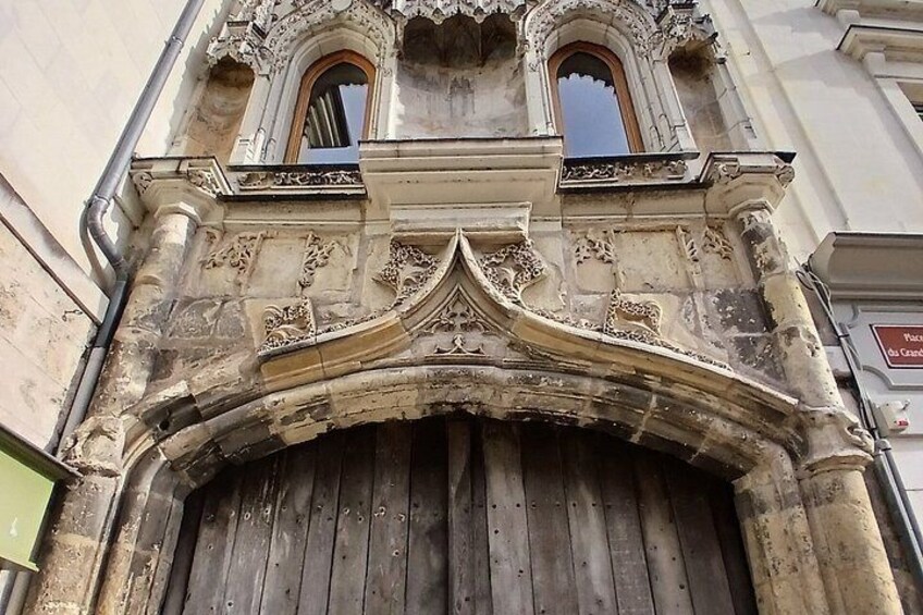 An ornate building facade with a large wooden door and intricate stone carvings. 3