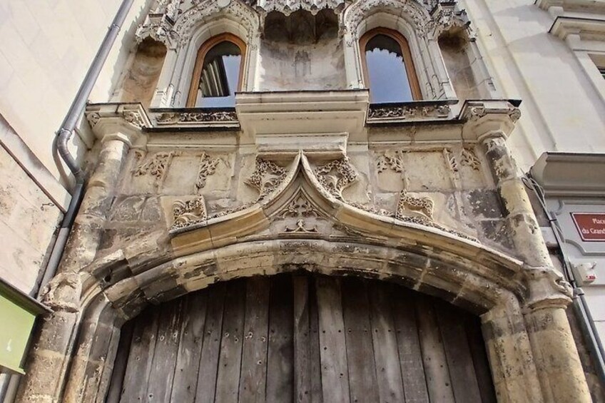 A historic building with ornate stone carvings and a large wooden door. 3