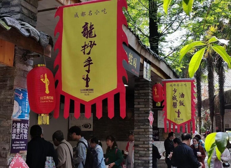 A traditional Chinese building with red lanterns and banners. 2