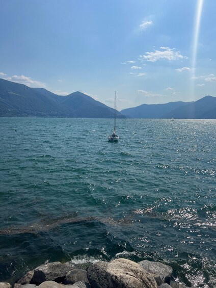 A sailboat on a calm lake with mountains in the background. 2