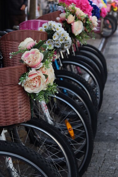A row of bicycles with wicker baskets and floral decorations. 5