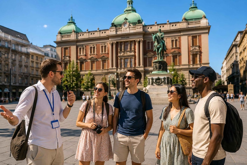 A group of people standing in front of a large building with domed roofs and a statue. 1