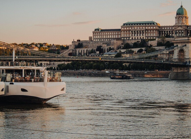 A river with a boat, a bridge, and a large building with a dome in the background. 5
