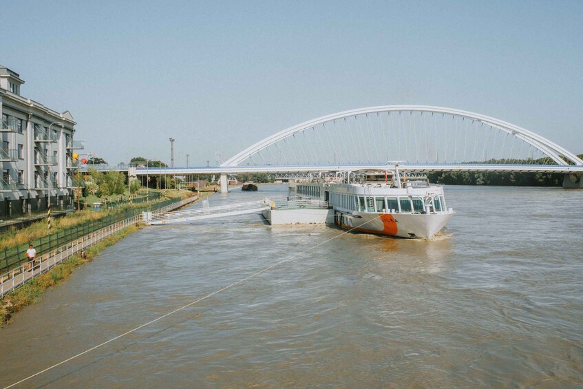 A river with a boat, a bridge, and a building. 2