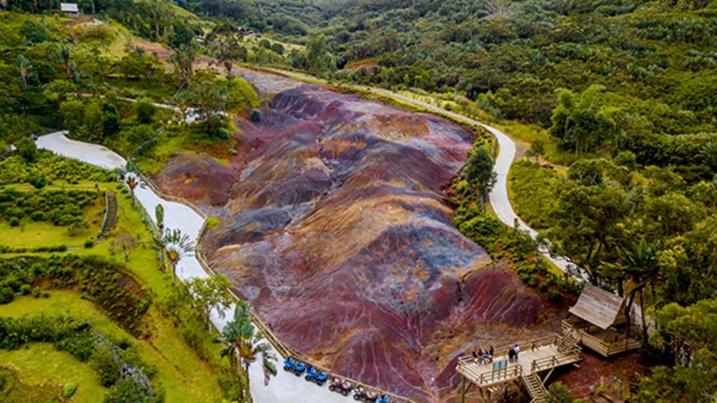 A river winding through a terraced landscape with a wooden viewing platform and a bridge. 2
