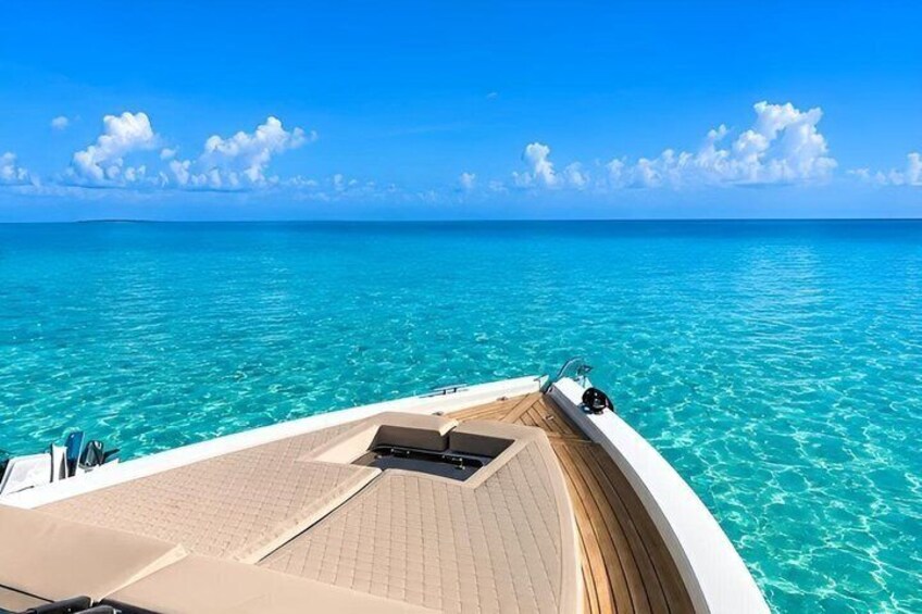 A boat deck with clear turquoise water and a blue sky. 4