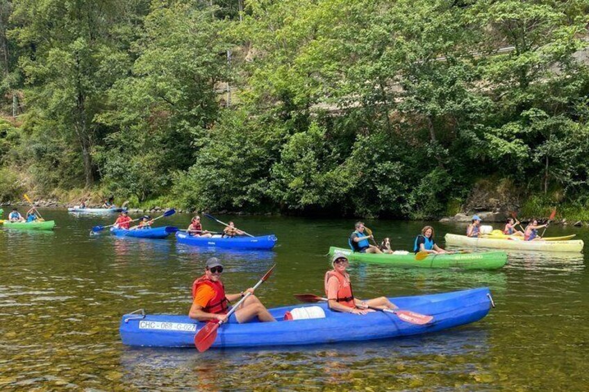 People kayaking on a calm river surrounded by dense greenery. 5