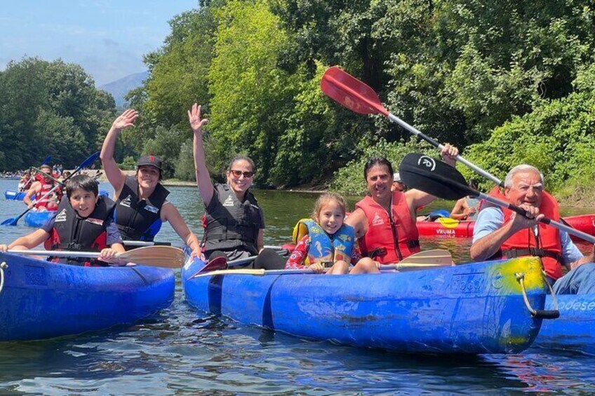 People in blue canoes on a river, wearing life jackets. 1