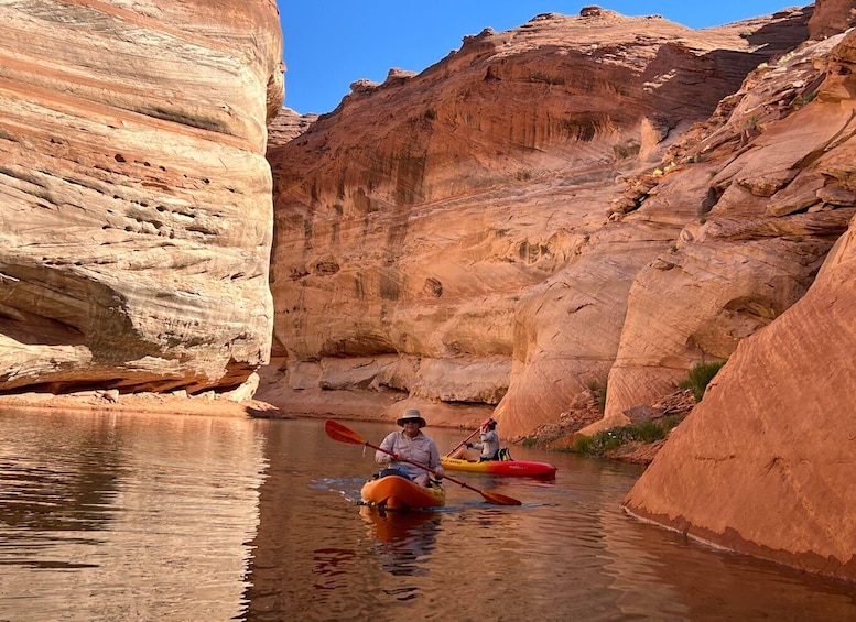 Kayakers navigating through a narrow canyon with steep rock walls. 3