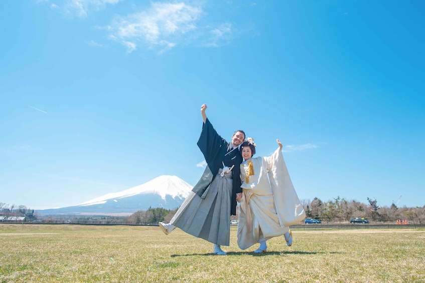 A couple in traditional attire, a field, and a mountain in the background. 5