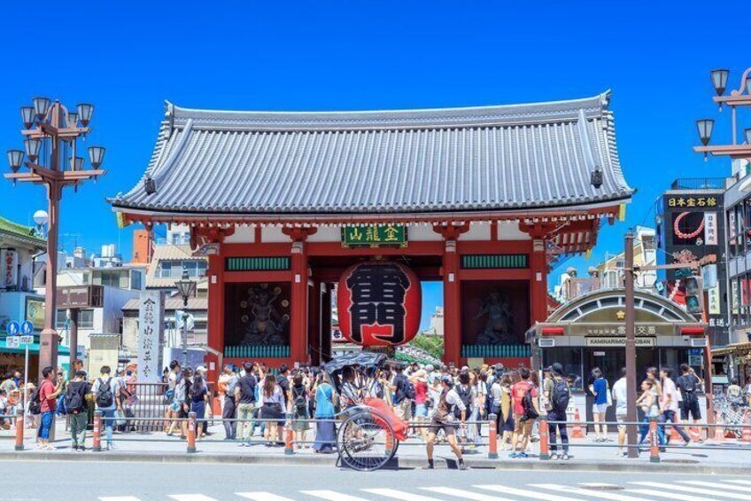 A traditional Japanese gate with people and bicycles in front. 4