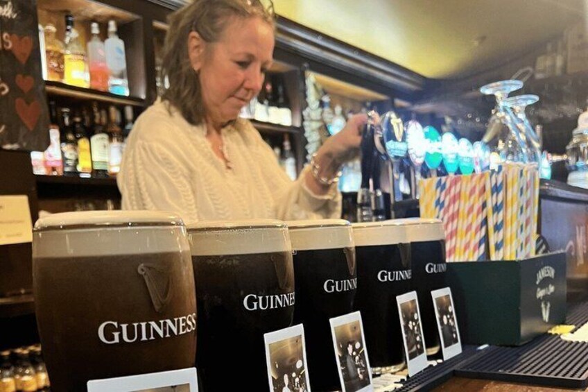 A bar with Guinness beer taps and a bartender. 4