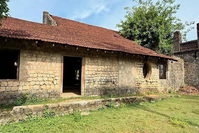 A stone house with a red-tiled roof, a wooden door, and a small window. 5
