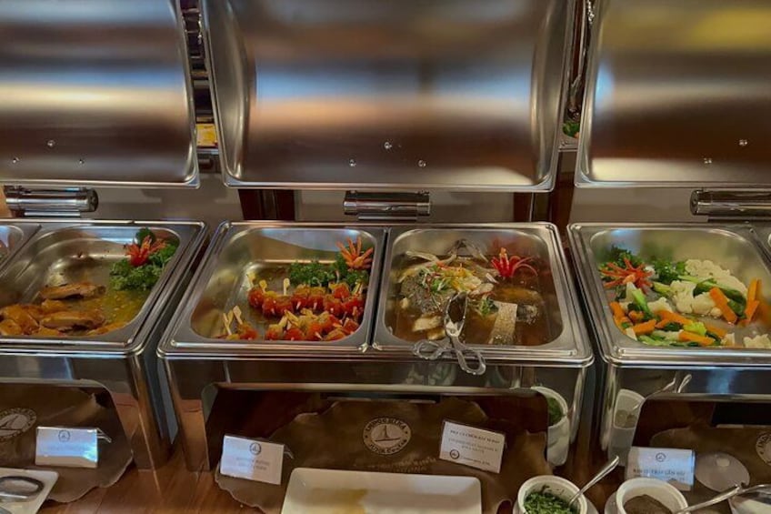 A buffet with various food items in metal containers. 4