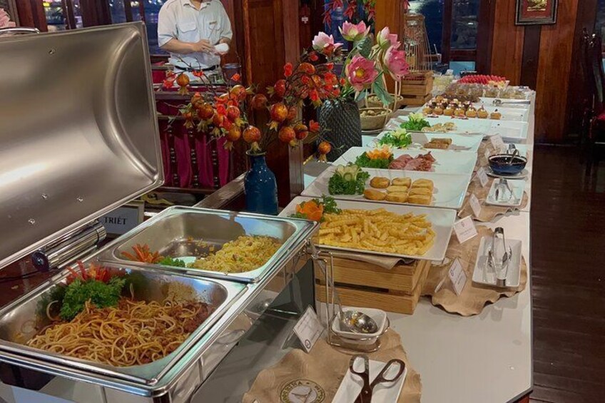 A buffet with various food items and a person in the background. 2