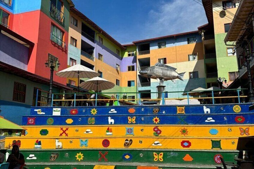 Colorful steps with various symbols and a fish sculpture. 3