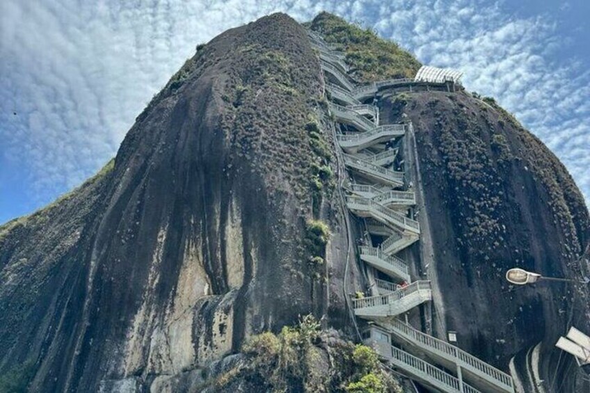 A steep, rocky mountain with a series of staircases and a viewing platform. 2