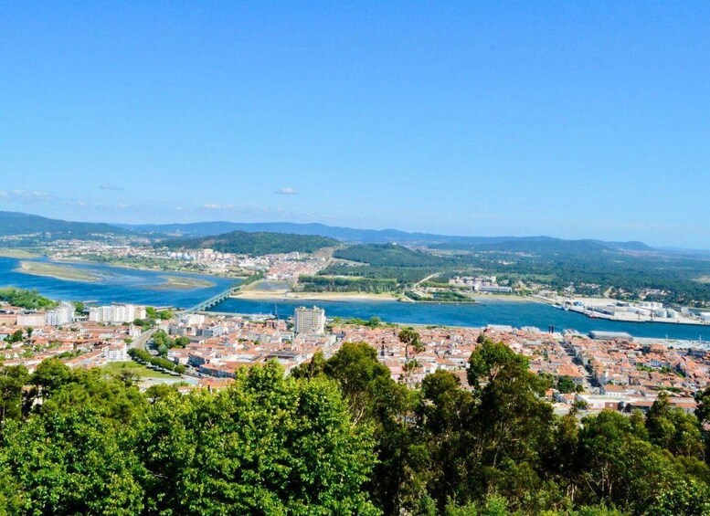 A coastal cityscape with a river, bridge, and industrial area. 4