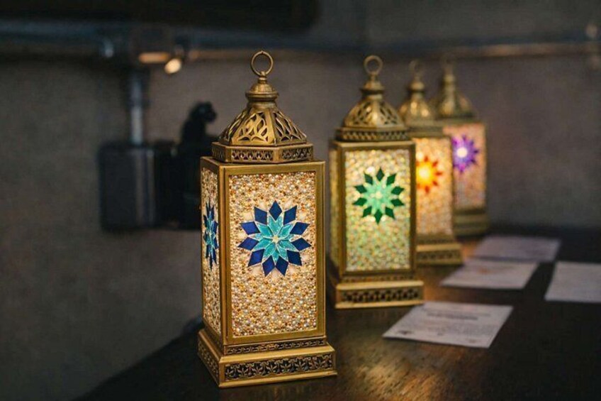 Three ornate lanterns with intricate designs and star patterns, placed on a wooden surface. 4