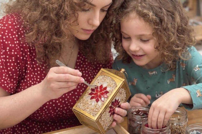 A person holding a decorative box with a bow, and another person pouring contents into a jar. 1