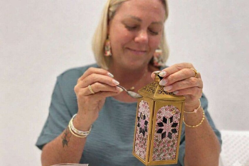 A person holding a decorative lantern with floral patterns. 2