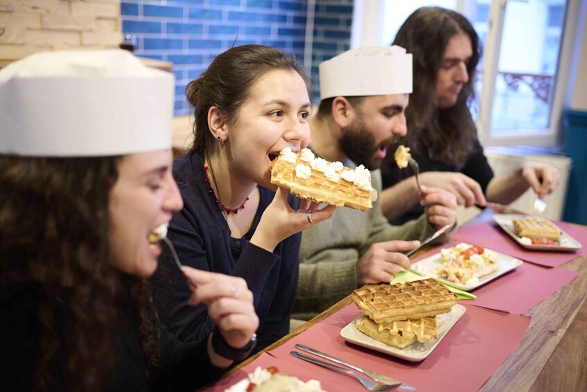 People eating waffles with toppings at a restaurant. 1