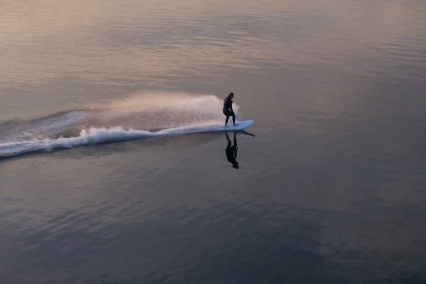 A person surfing on a calm sea. 2