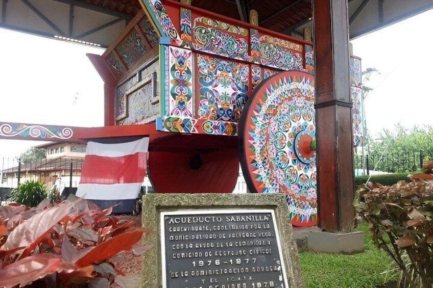 A colorful, intricately decorated structure with a sign indicating it is a historical site from 1976-1977. 3