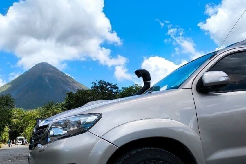 A car parked with a mountain in the background. 1