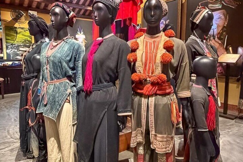 Mannequins dressed in traditional attire, with one wearing a red scarf and another adorned with orange pom-poms. 5