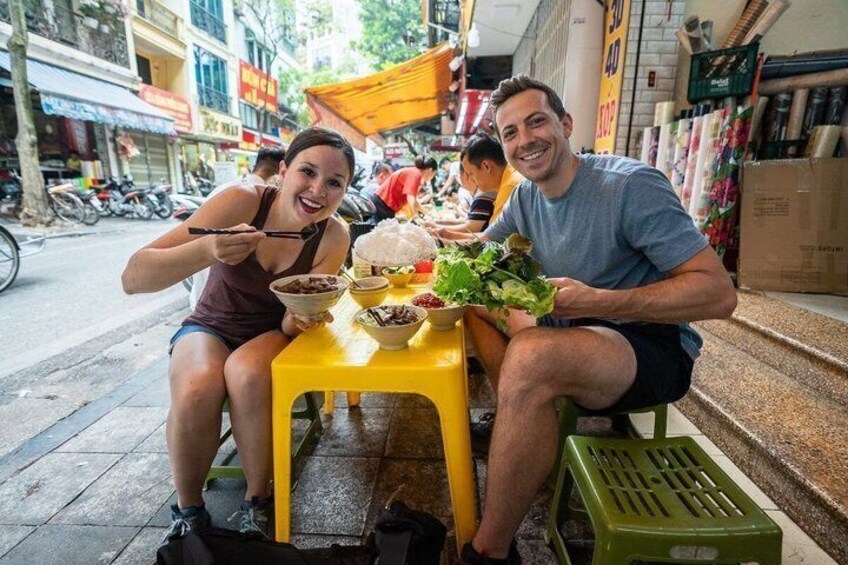 A street food stall with people eating. 1