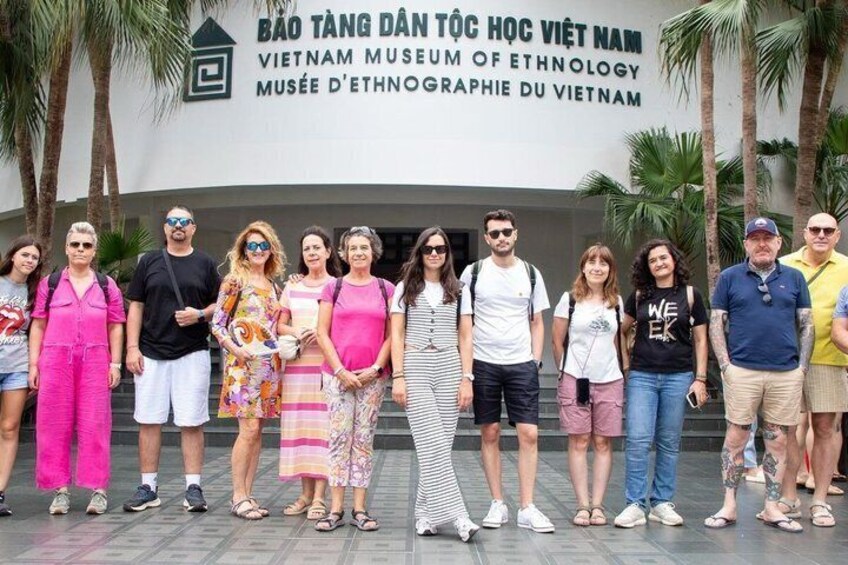 A group of people standing in front of a building with a sign that reads 'BÀO TÀNG DÂN TỐC HỌC VIỆT NAM VIETNAM MUSEUM OF ETHNOLOGY MUSEE D'ETHNOGRAPHIE DU VIETNAM'. 4