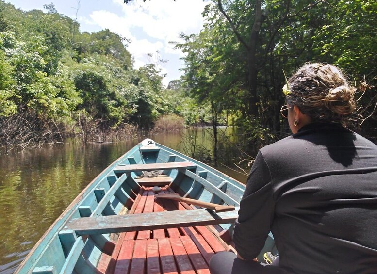 A person in a boat on a river surrounded by dense greenery. 2