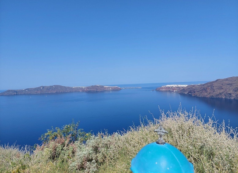 A coastal landscape with clear blue sea, rocky islands, and sparse vegetation. 4