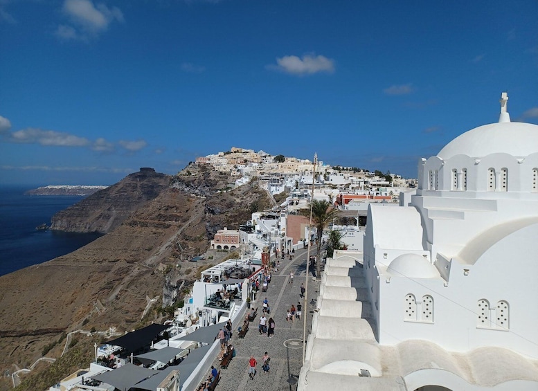 A coastal town with white buildings, a hilltop settlement, and the sea. 5