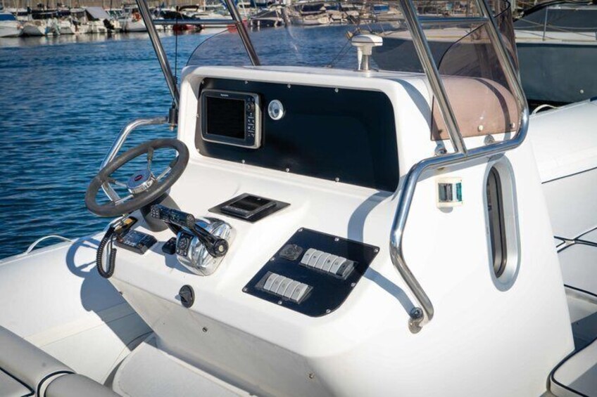 A boat's control panel with a steering wheel, navigation screens, and a cushioned seat. 4