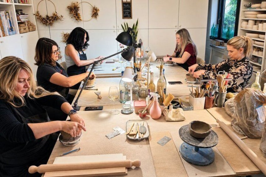 A pottery workshop with participants engaged in crafting pottery. 1