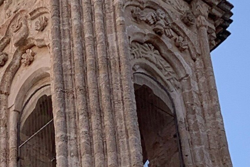 A stone column with intricate carvings and a large arched doorway. 2