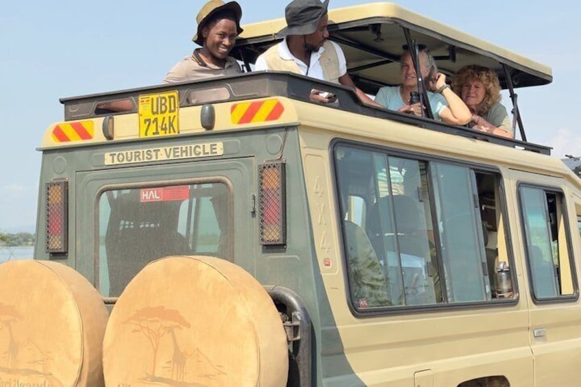 A tourist vehicle with passengers, a visible license plate, and a rear view of the vehicle. 1