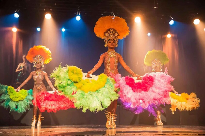 A stage performance with dancers in colorful costumes and feathered headdresses. 4