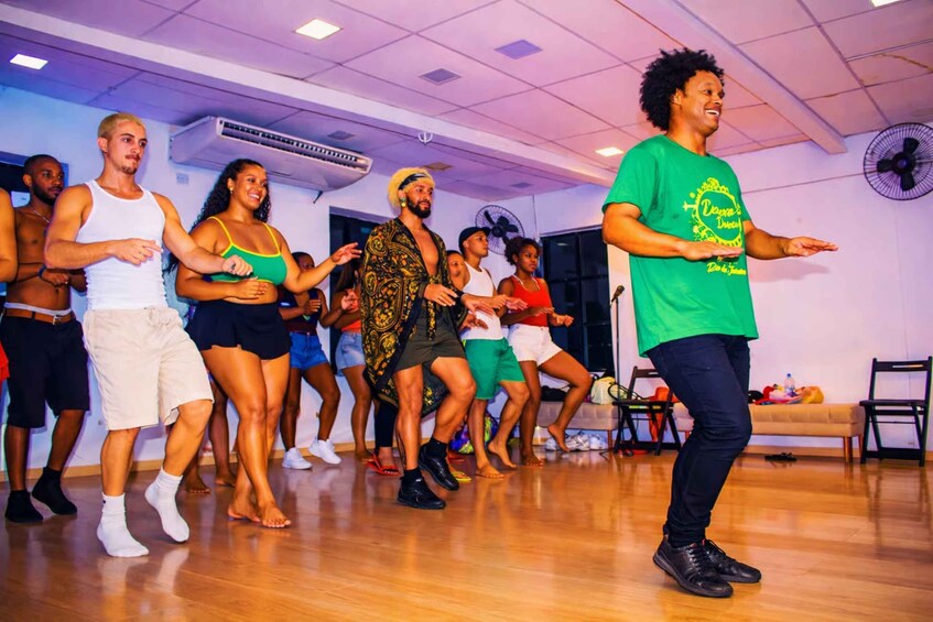 A group of people in a dance studio with wooden floors and a white ceiling. 3