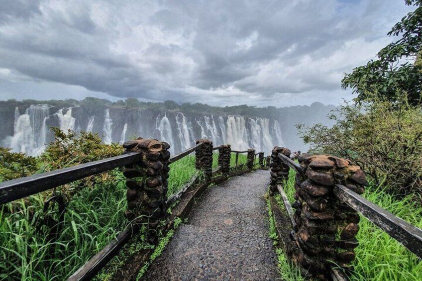 A stone pathway leading to a waterfall. 2